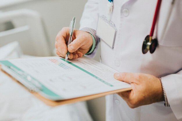 Médico especialista preenchendo prontuário durante perícia médica PCD para residência